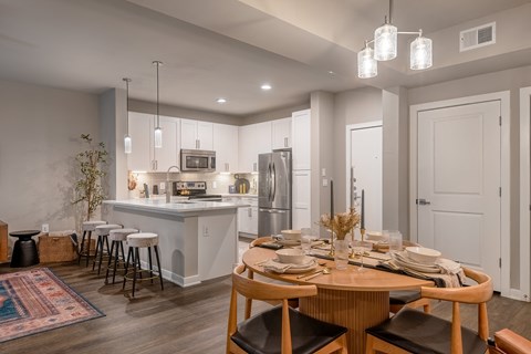 an open kitchen and dining room with a table and chairs at The Can Plant Residences at Pearl, San Antonio, Texas