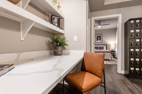 an office with a desk and a chair in a room with a bedroom at The Can Plant Residences at Pearl, San Antonio, TX