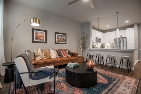 a living room with a couch and a table at The Can Plant Residences at Pearl, San Antonio, TX, 78215
