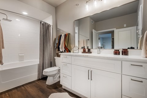 a bathroom with a large mirror and a toilet and a shower at The Can Plant Residences at Pearl, San Antonio, TX