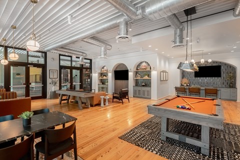 a game room with a pool table and a television at The Can Plant Residences at Pearl, San Antonio, Texas