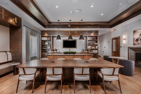 A modern dining room with a large wooden table and chairs.
