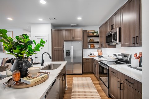 A modern kitchen with wooden cabinets and stainless steel appliances.