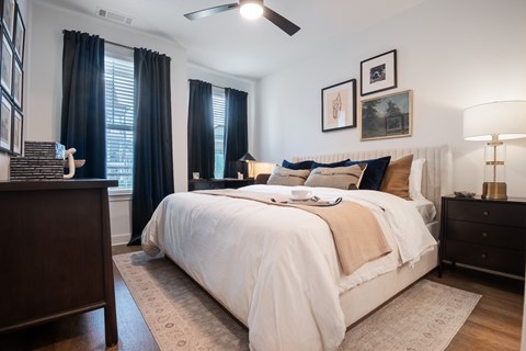 A bedroom with a large bed and a ceiling fan.