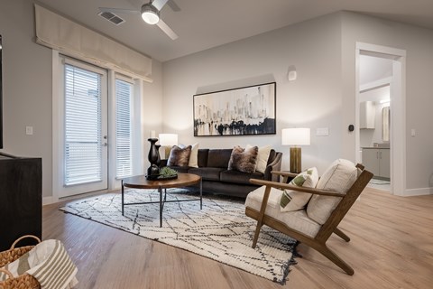 A living room with a couch, a coffee table, and a painting on the wall.