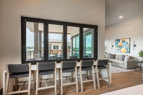 A dining room with a table and chairs in front of a large window.