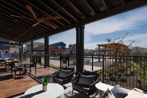 a patio with chairs and tables and a swimming pool