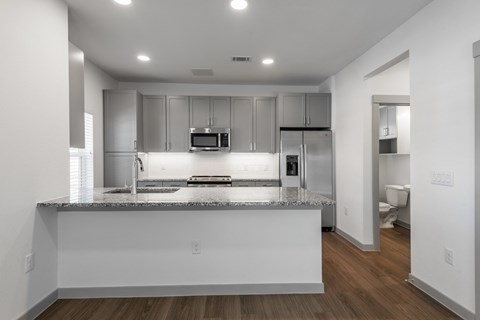 an empty kitchen with a granite counter top and