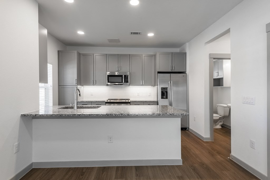 an empty kitchen with a granite counter top and