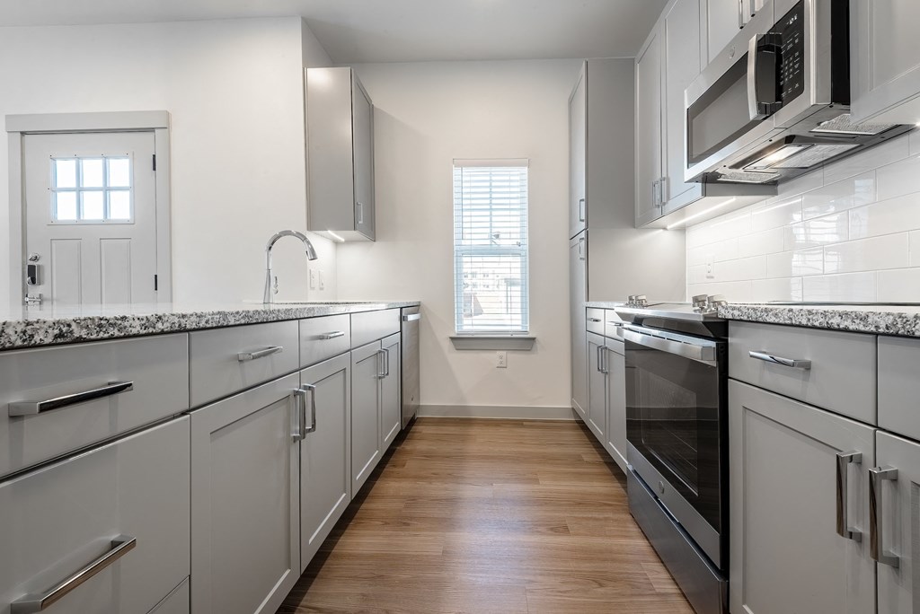 a kitchen with white cabinets and stainless steel appliances