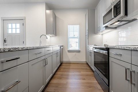 a kitchen with white cabinets and stainless steel appliances