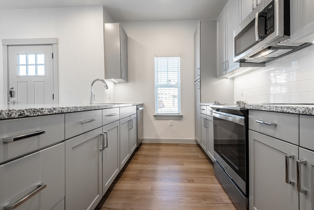a kitchen with white cabinets and stainless steel appliances
