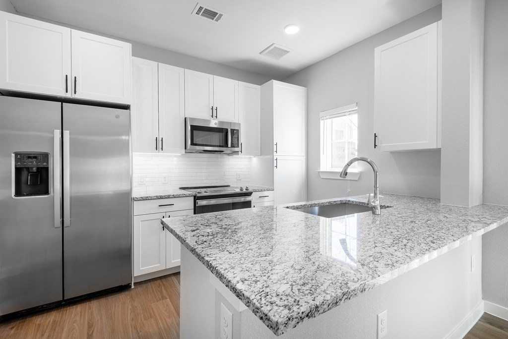 a kitchen with granite counter tops and stainless steel appliances