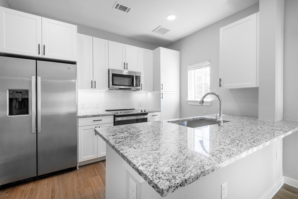 a kitchen with granite counter tops and stainless steel appliances