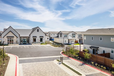 an empty parking lot in front of a row of houses
