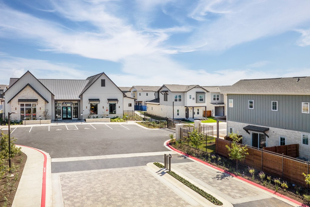 an empty parking lot in front of a row of houses