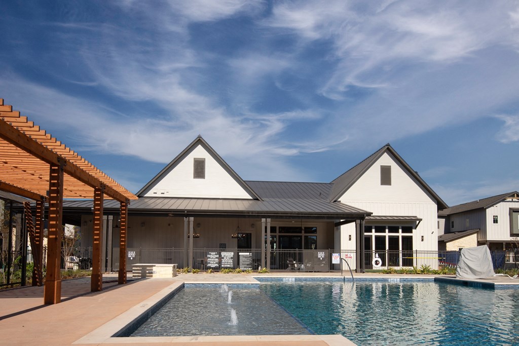 a large pool in front of a house with a blue sky