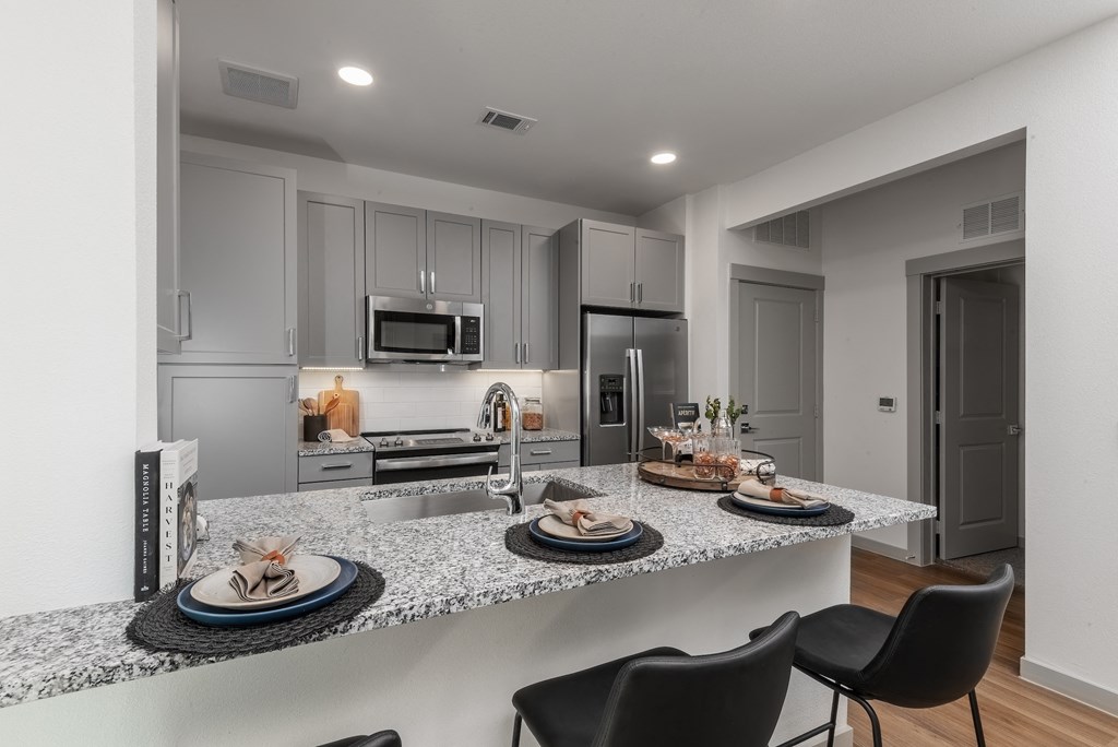 a kitchen with granite counter tops and a island with plates of food
