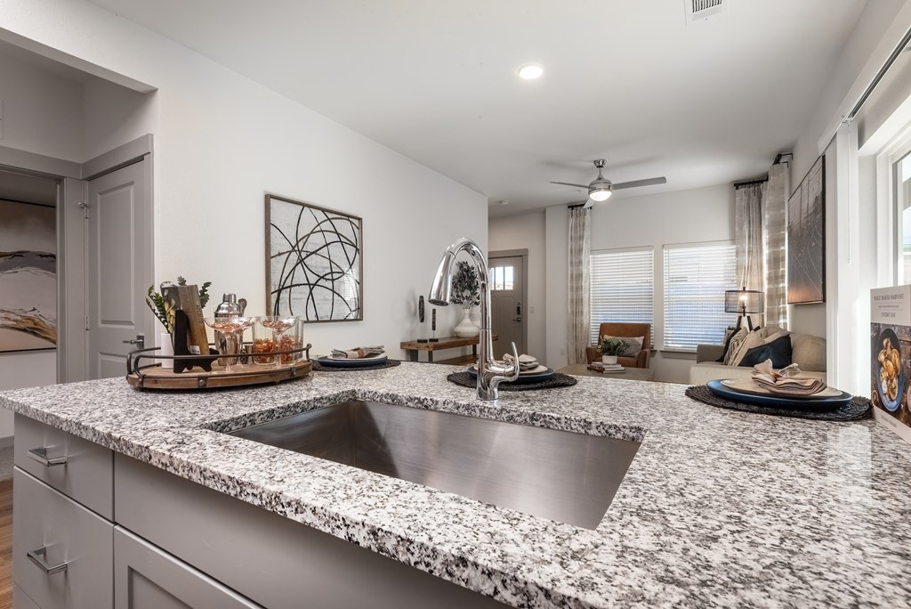 an open kitchen with granite counter tops and a sink