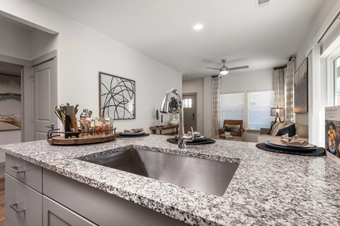 an open kitchen with granite counter tops and a sink