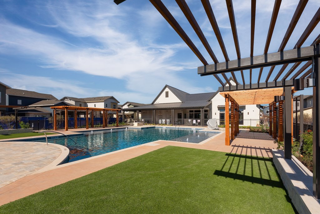 a large swimming pool with a house in the background