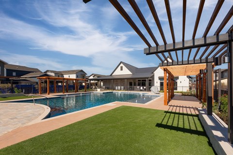 a large swimming pool with a house in the background