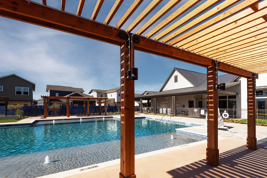 a swimming pool with a wooden structure in front of a house