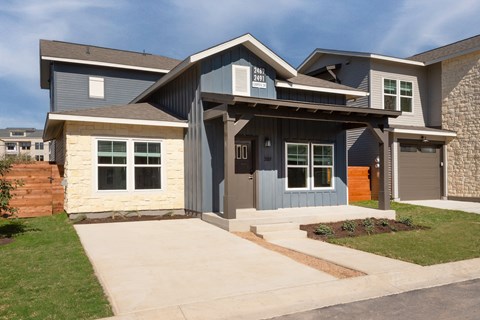 a blue house with a sidewalk in front of it