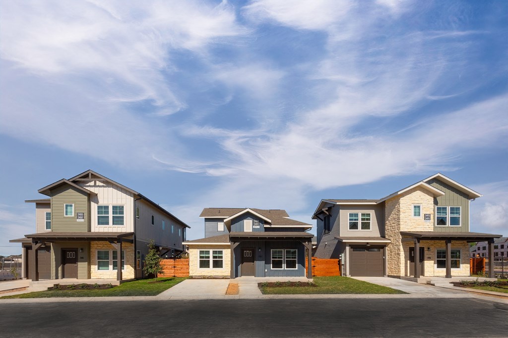 a row of houses on a street under a blue sky