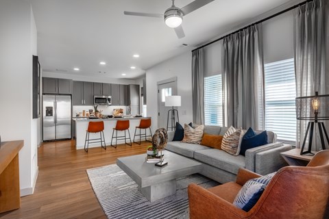A modern living room with a grey couch and a grey coffee table.