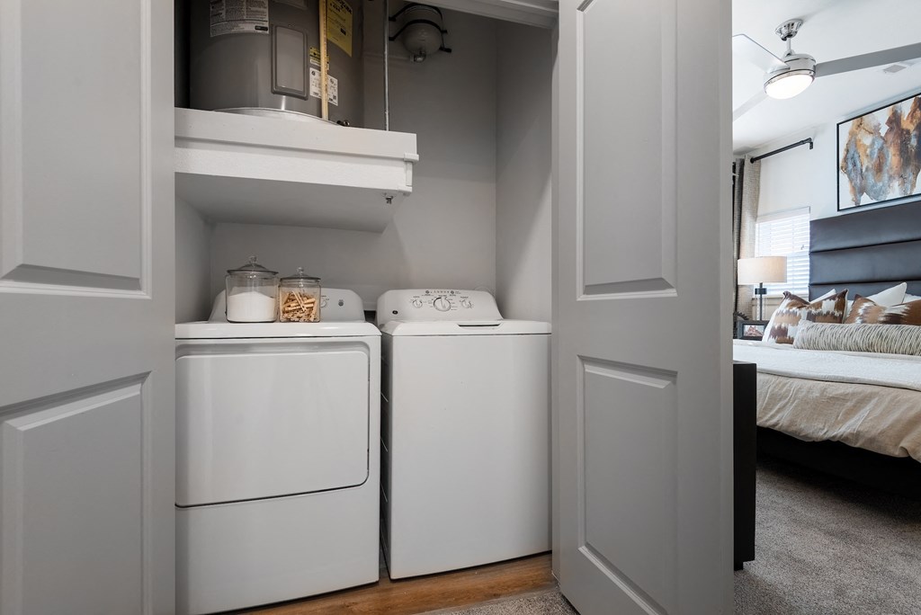 a white washer and dryer in a room next to a bedroom