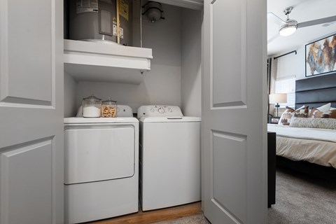a white washer and dryer in a room next to a bedroom