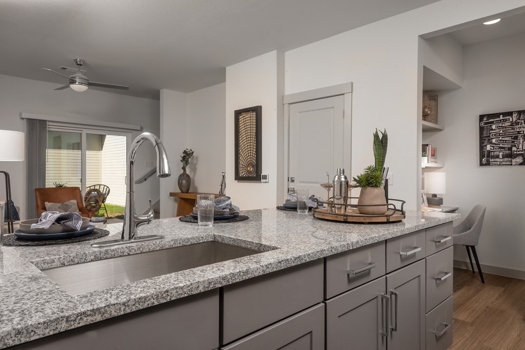 an open kitchen with granite counter tops and a sink