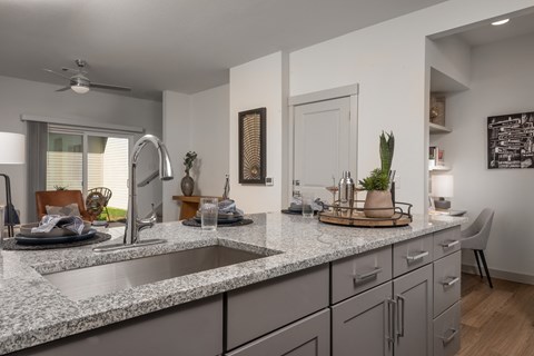 an open kitchen with granite counter tops and a sink