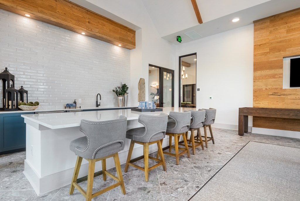 a kitchen with a long counter and bar chairs