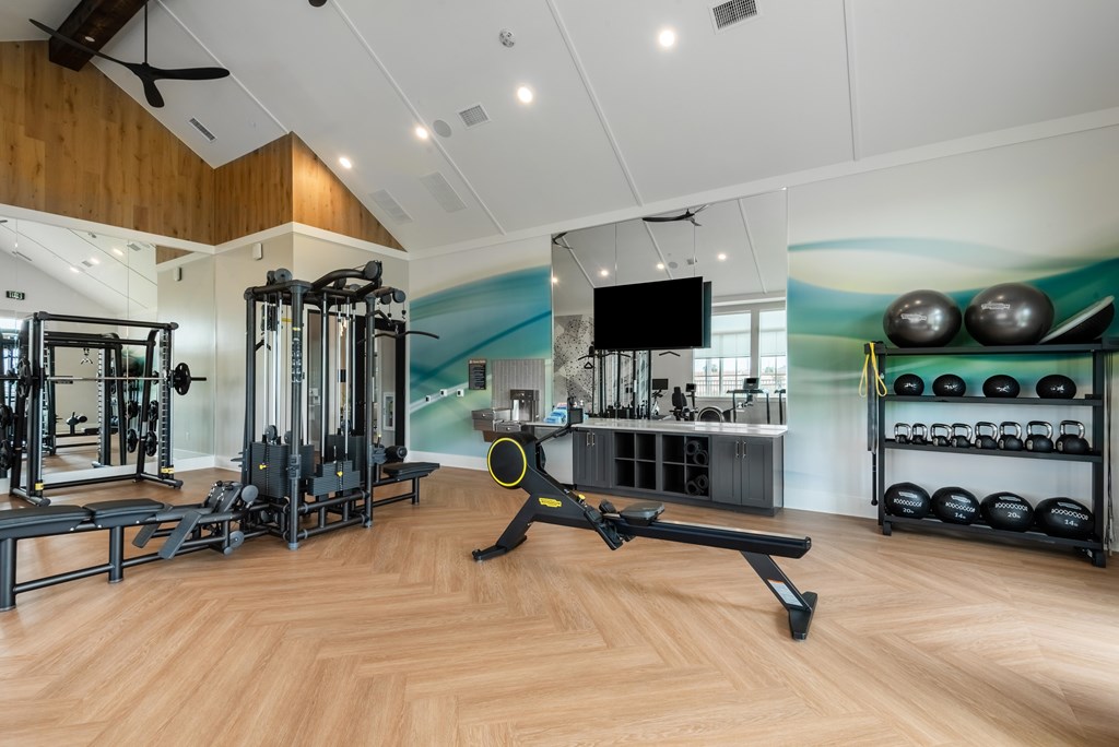 A gym with a variety of equipment including a rowing machine.