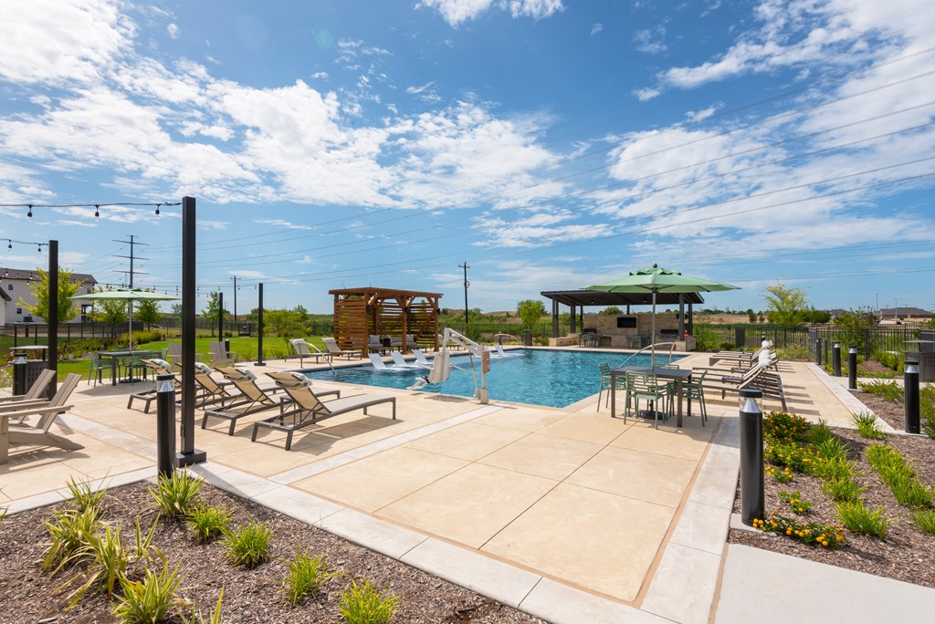 A pool area with sun loungers and a wooden structure.