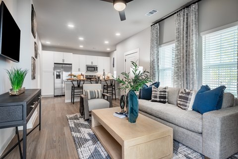 A modern living room with a grey couch and a wooden coffee table.