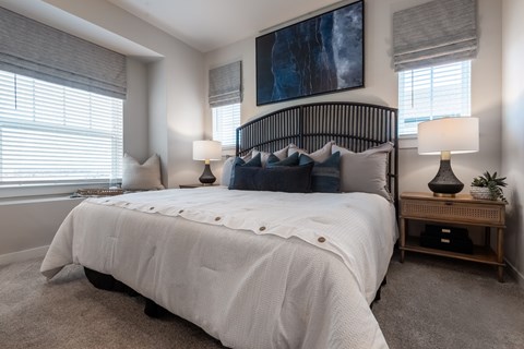 A bedroom with a large bed and a painting on the wall.