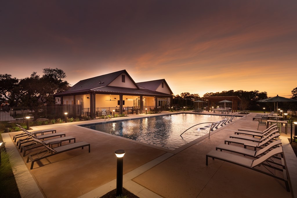 A large building with a pool in front of it at dusk.