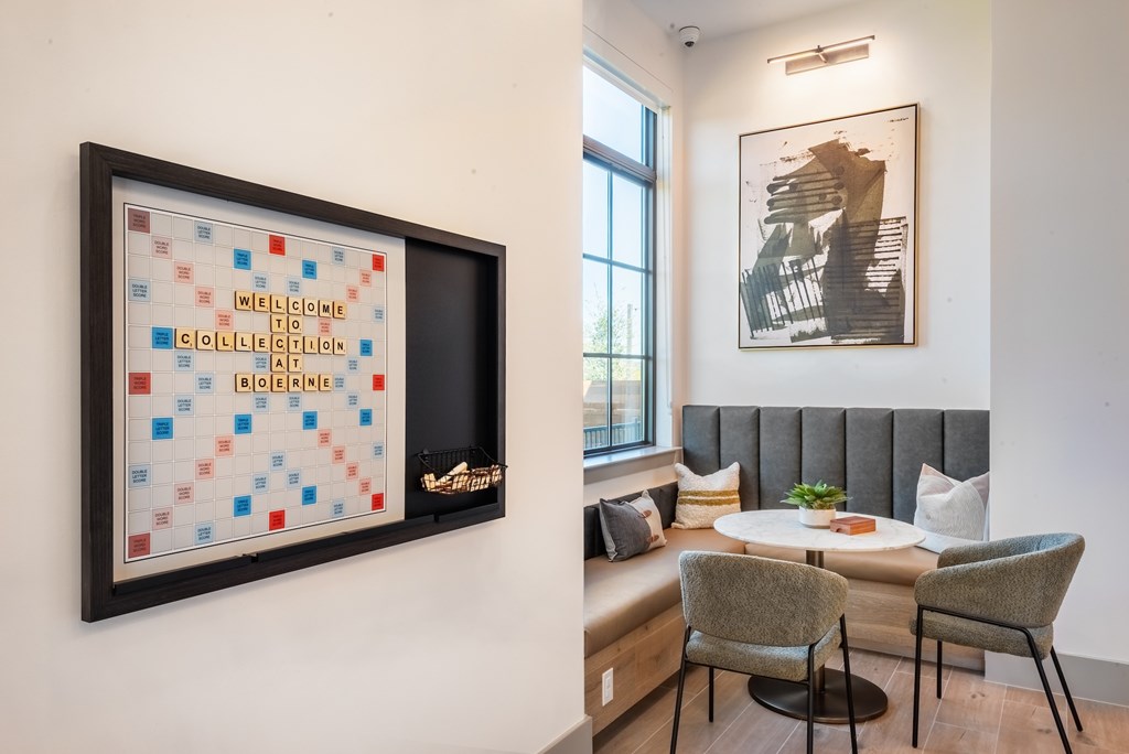 A framed artwork with the word "welcome" written on it is hanging on a wall next to a window.