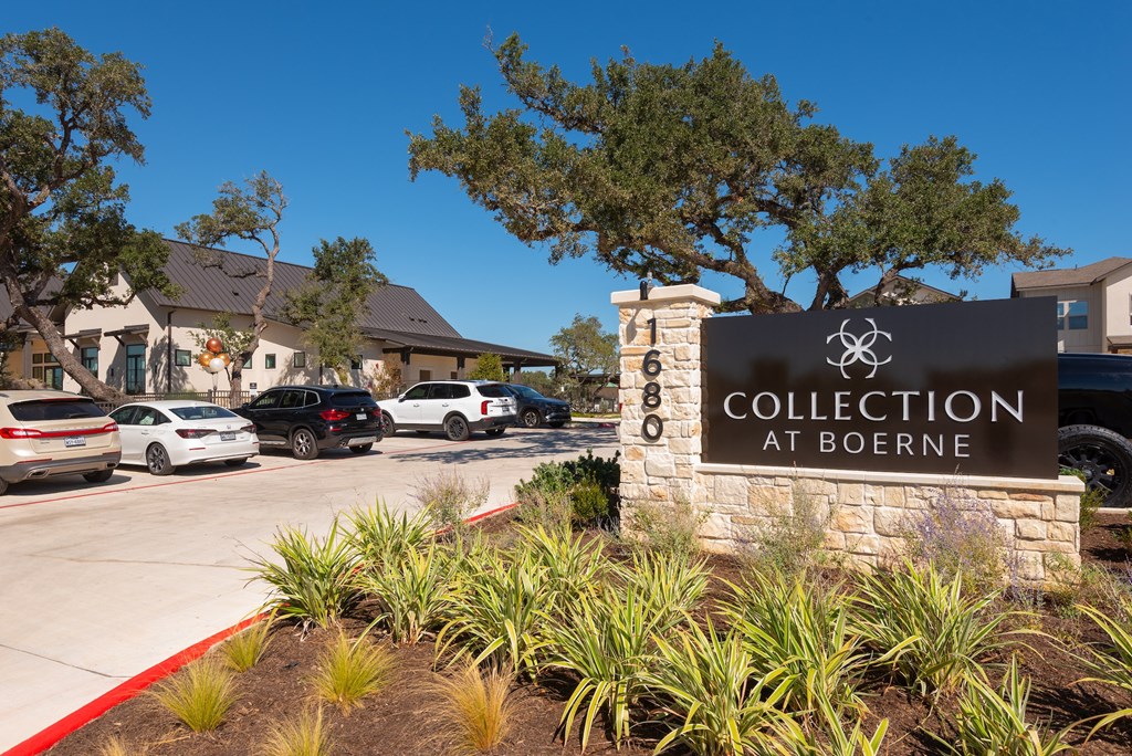 A sign that says Collection at Boerne in front of a parking lot.