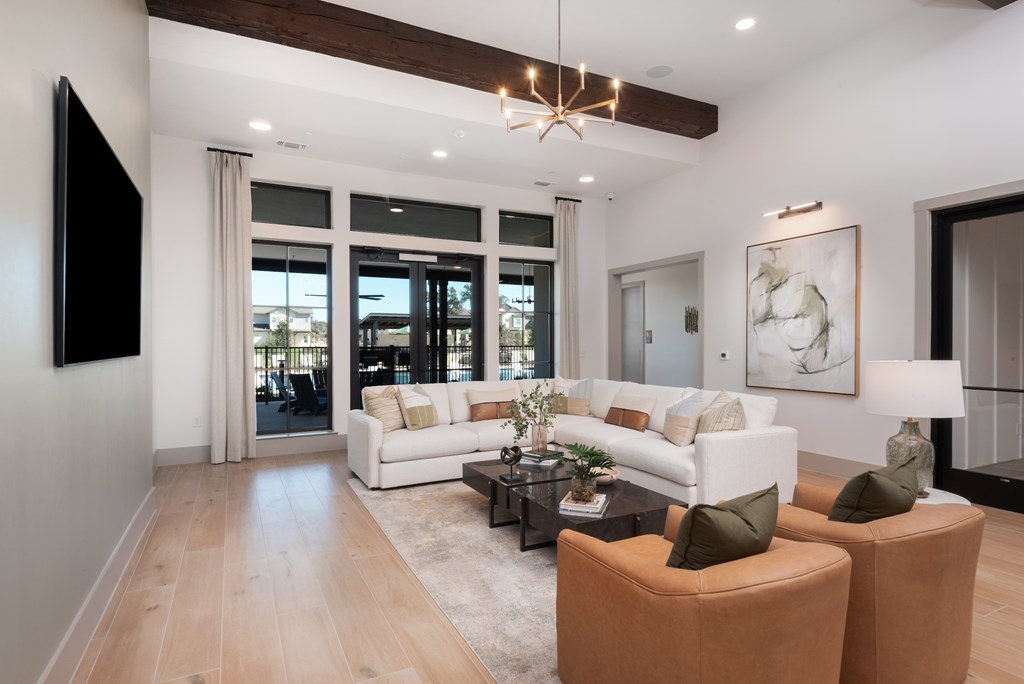 A modern living room with a white sofa, brown armchairs, and a wooden coffee table.