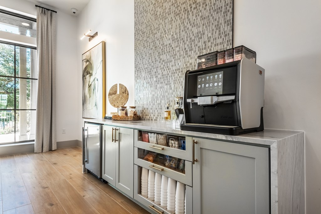 A modern kitchen with a large window and a wooden floor.