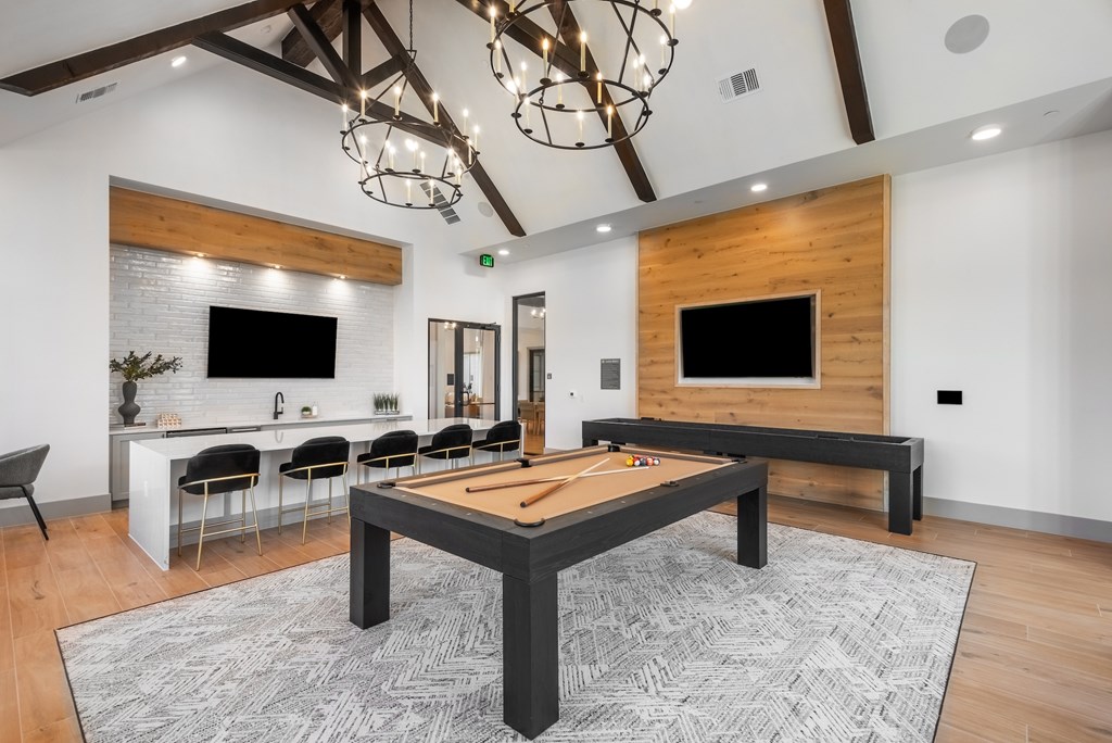 A room with a foosball table in the middle of the room.