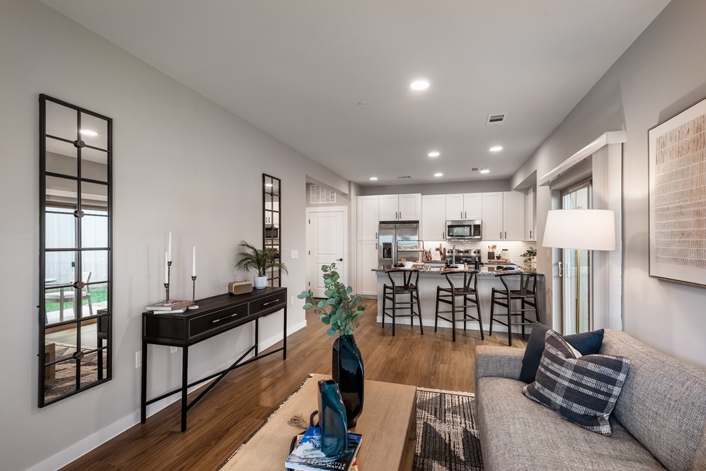 A modern living room with a grey sofa and a black desk.