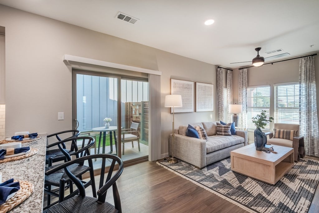 A well-lit living room with a dining table and chairs.