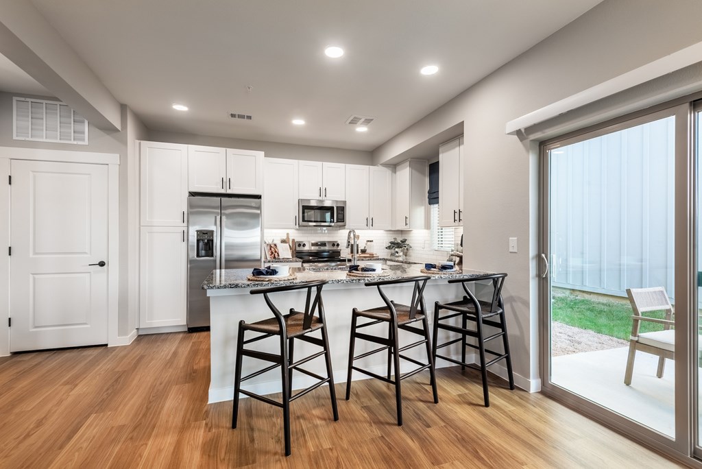 A kitchen with a bar stool in front of the island.