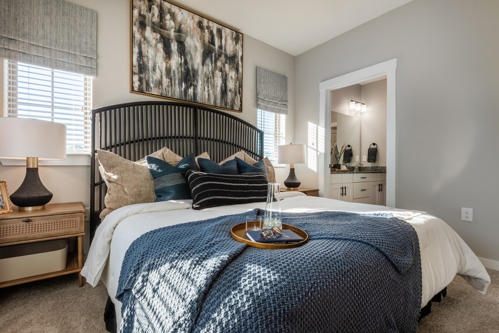 A bedroom with a large bed and a painting on the wall.
