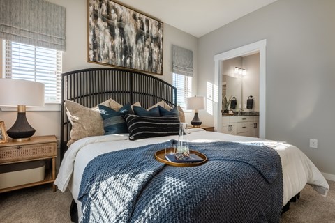 A bedroom with a large bed and a painting on the wall.